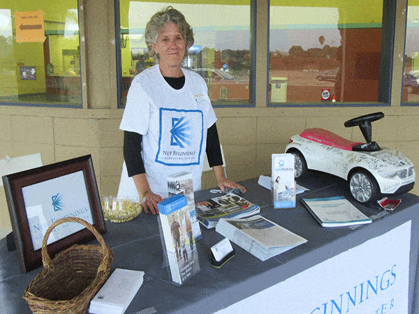 Board President Jacqueline Kurta poses for a picture in front of an information table set up for the fundraiser